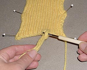 Fransenenden durch die Schlaufe ziehen Fransenenden durch die Schlaufe ziehen